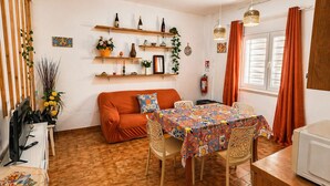 Un salon confortable avec un canapé, une table à manger et des chaises, un téléviseur et une cheminée.