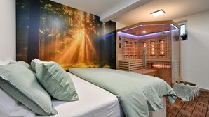 A bedroom with a large forest mural, a glass-enclosed reading nook, and a wooden floor.