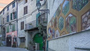 A narrow street with buildings featuring traditional architecture, including a green door and a balcony with a wrought iron railing. - 1 bedroom amazing home in Onzo (Onzo)