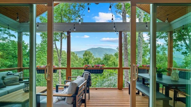 A covered outdoor area with seating and a view of a mountainous landscape. - 5 mi. to Asheville•HotTub•Sauna•MtnViews•FirePit•PoolTable (Swannanoa)