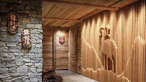 Un mur de pierre avec des poutres en bois, un banc en bois et un mur en bois avec des lattes verticales.