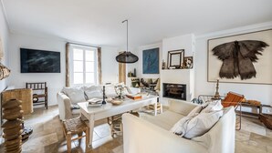 Un salón espacioso con un sofá blanco, una mesa de comedor y una chimenea.
