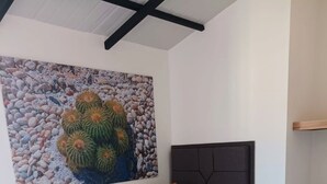 A bed with a dark headboard, white bedding, and two brown pillows. - Jardines del Lago  (Guatapé)