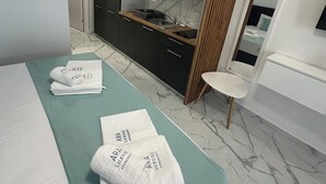 Habitació d'hotel moderna amb un llit, un bany i una cuineta.