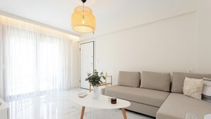 Un saló modern amb un sofà, una taula de centre i una làmpada penjant.