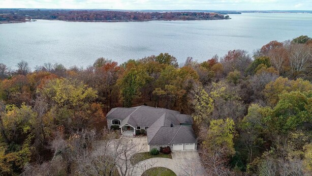 A house surrounded by autumn foliage, overlooking a large body of water. - Lakefront Hideaway - Boat Slip at Nearby Marina (Grove)