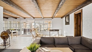 A modern living room with a wooden ceiling, a grey sofa, a wooden coffee table, and a globe on a side table. - Stunning home in Blokhus with sauna (Blokhus)