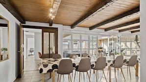 A dining area with a large table, chairs, and a view of the outside through large windows. - Stunning home in Blokhus with sauna (Blokhus)