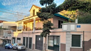 Edifici de dues plantes amb un balcó, un garatge i un senyal que indica la ubicació.