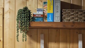 En trævæg med en reol fyldt med bøger og en hængende plante.