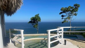 A pool area with a clear view of the ocean, surrounded by white railings and a thatched roof structure. - Hotel Marshell (Chimo)