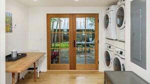 A laundry room with a wooden table, chairs, and a washing machine. - Lincoln Lodge! Steps from the heart of Elk Avenue! (Crested Butte)