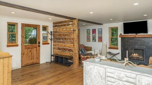 A modern living room with a fireplace, wooden accents, and artwork on the walls. - Lincoln Lodge! Steps from the heart of Elk Avenue! (Crested Butte)