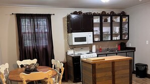 Um espaço compacto com área de jantar, cozinha compacta e um pequeno espaço para sentar.