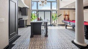 A spacious indoor area with a pool table, a dining table with chairs, and a kitchen area with cabinets and a window. - Fruit Trees, Farm Stay, Ranch Retreat, Lake Access (Fallbrook)