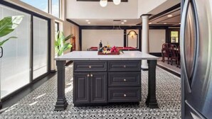 A spacious room with a large window, a central island with drawers, and a chandelier. - Fruit Trees, Farm Stay, Ranch Retreat, Lake Access (Fallbrook)