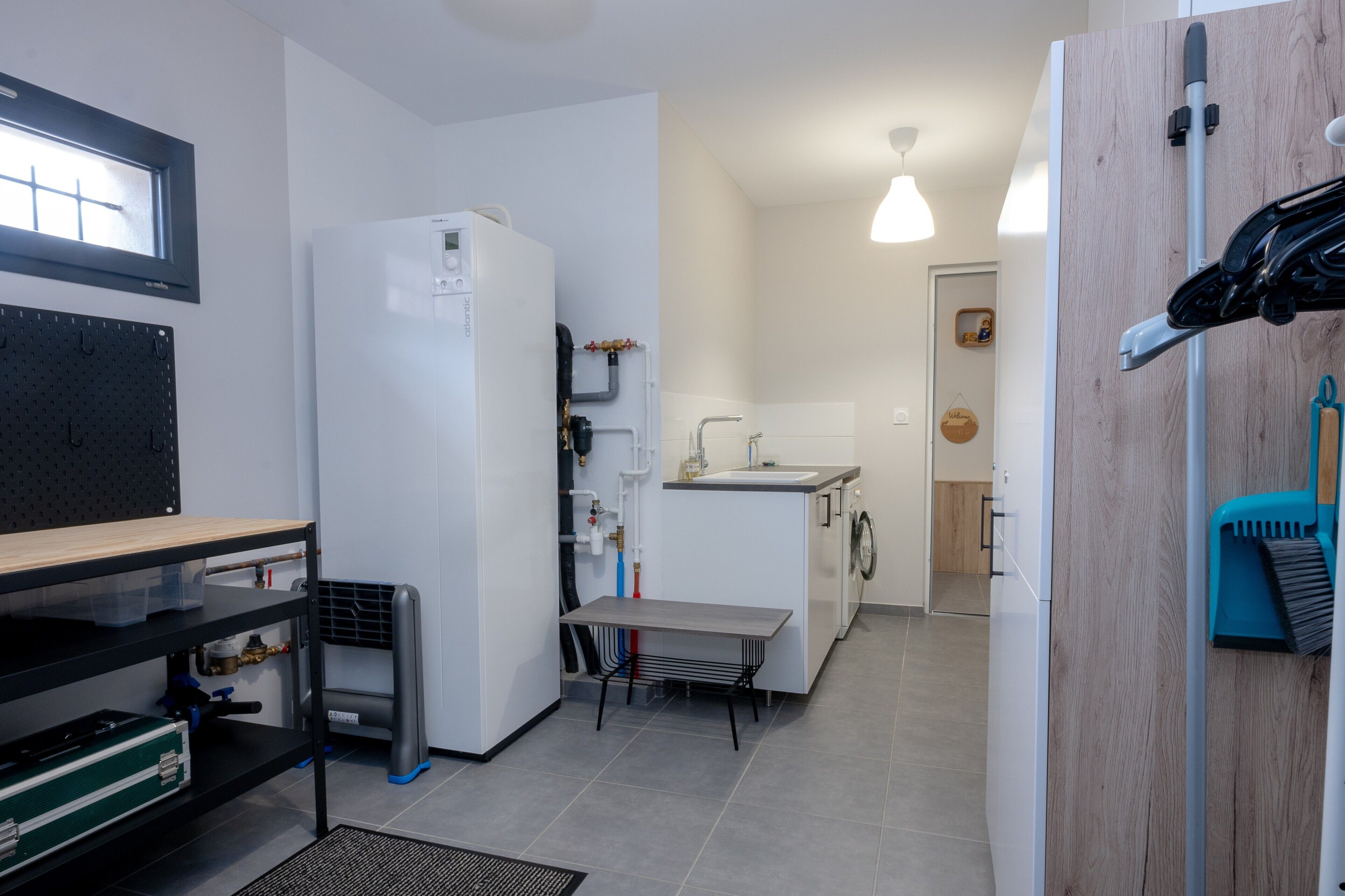 Eine kleine Küche mit Kühlschrank, Waschmaschine und Spüle.