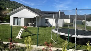 A house with a fenced yard, a trampoline, and a clear blue sky. - Holiday Home 'Les Chaudannes' with Mountain View, Wi-Fi, and Air Conditioning (Valgelon-La Rochette)