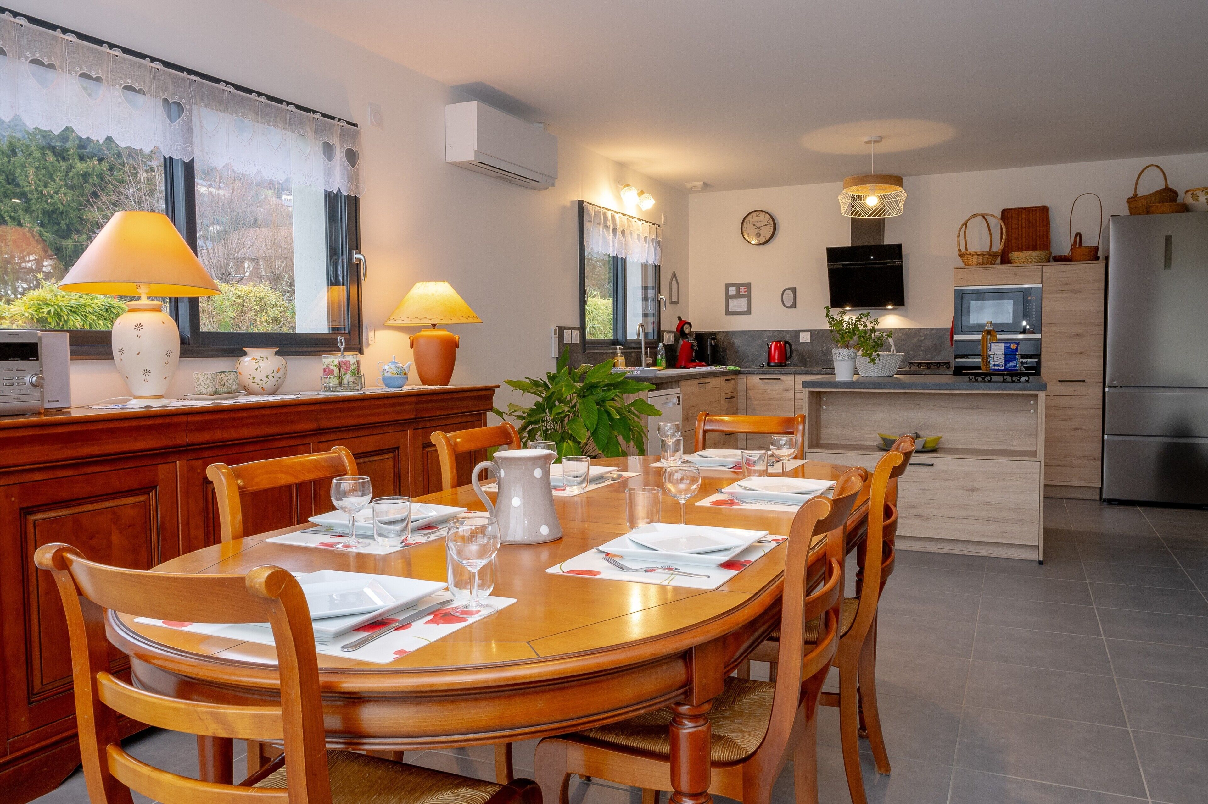 Una cocina moderna con comedor, muebles de madera y vistas al exterior.