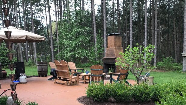 A patio with outdoor furniture, a fire pit, and a pergola. - Charming 4-bedroom house in Interlochen. Your home away from home.  (Interlochen)