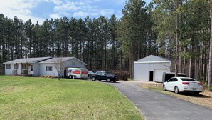 A U-Haul truck parked in front of a house with a garage and a shed. - Charming 4-bedroom house in Interlochen. Your home away from home.  (Interlochen)