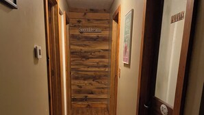 A wooden-paneled hallway with a sign reading "Sweet Dreams" on the wall. - Charming 4-bedroom house in Interlochen. Your home away from home.  (Interlochen)