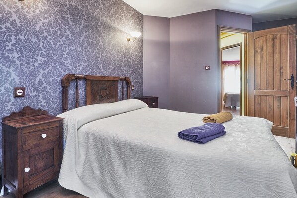 Ein Schlafzimmer mit einem Bett, einem Nachttisch aus Holz und einem Kleiderschrank.