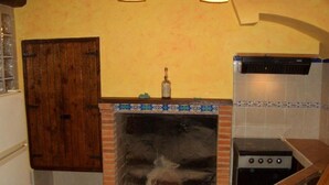 Cozinha com painel de azulejos, fogão e porta de madeira.