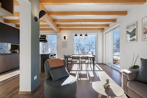 A modern interior with a dining area, kitchen, and seating.