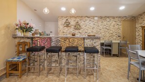 A kitchen with a bar area, a dining table, and chairs.