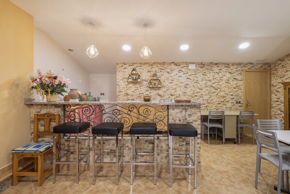 Une cuisine avec un coin bar, une table à manger et des chaises.