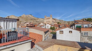 A view of a town with buildings, a church, and a hill in the background.