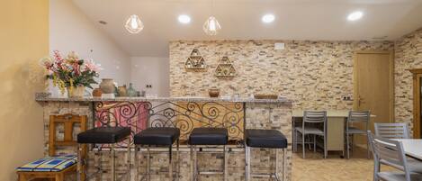 Una cocina con barra, una mesa de comedor y sillas.