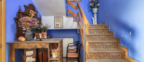 Una escalera con escalones ornamentados y un escritorio de madera con un jarrón de flores.