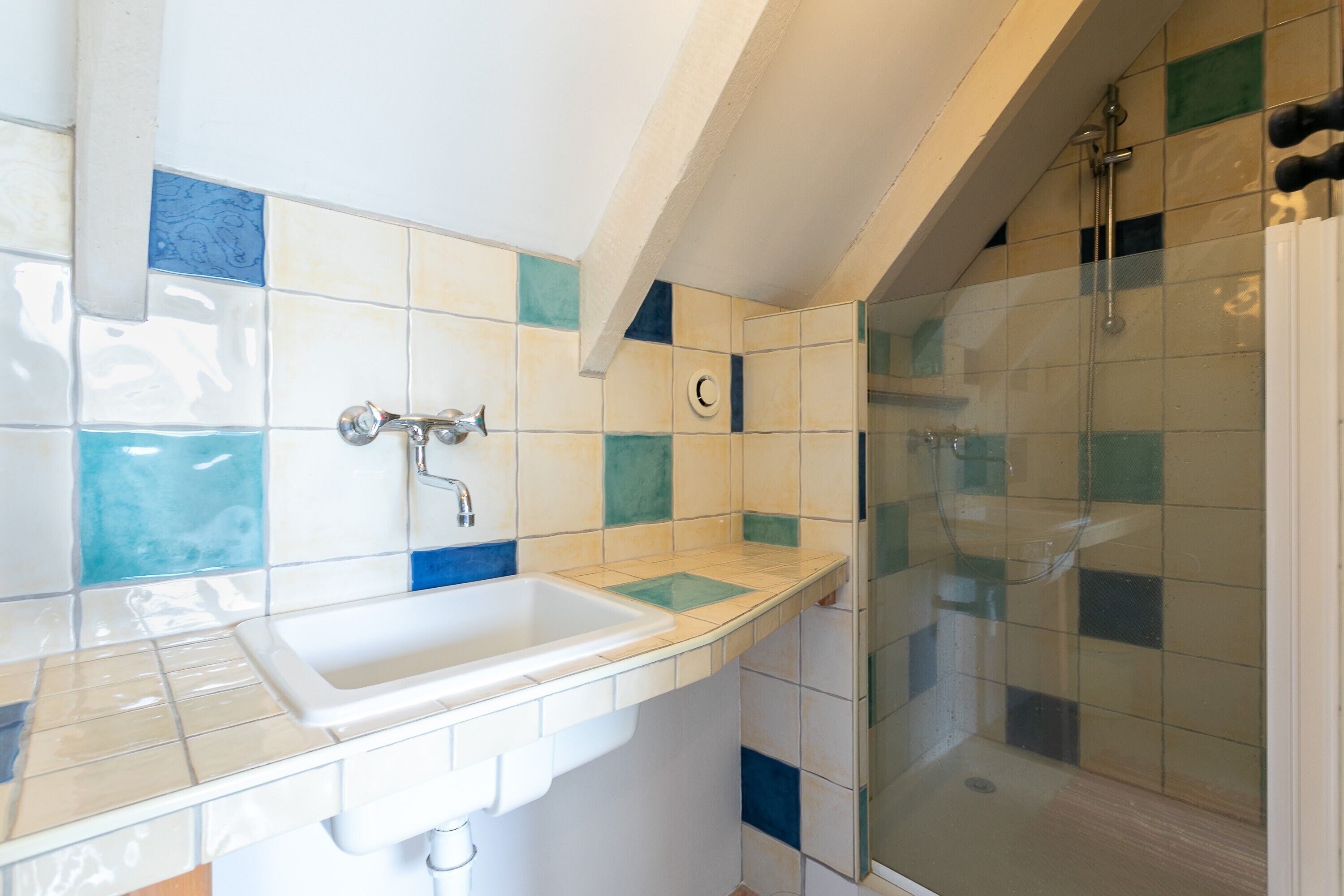 Ein Badezimmer mit Waschbecken, Spiegel und Duschbereich.