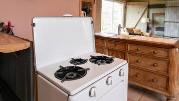 Una cucina con un piano cottura bianco, mobili in legno e una finestra.