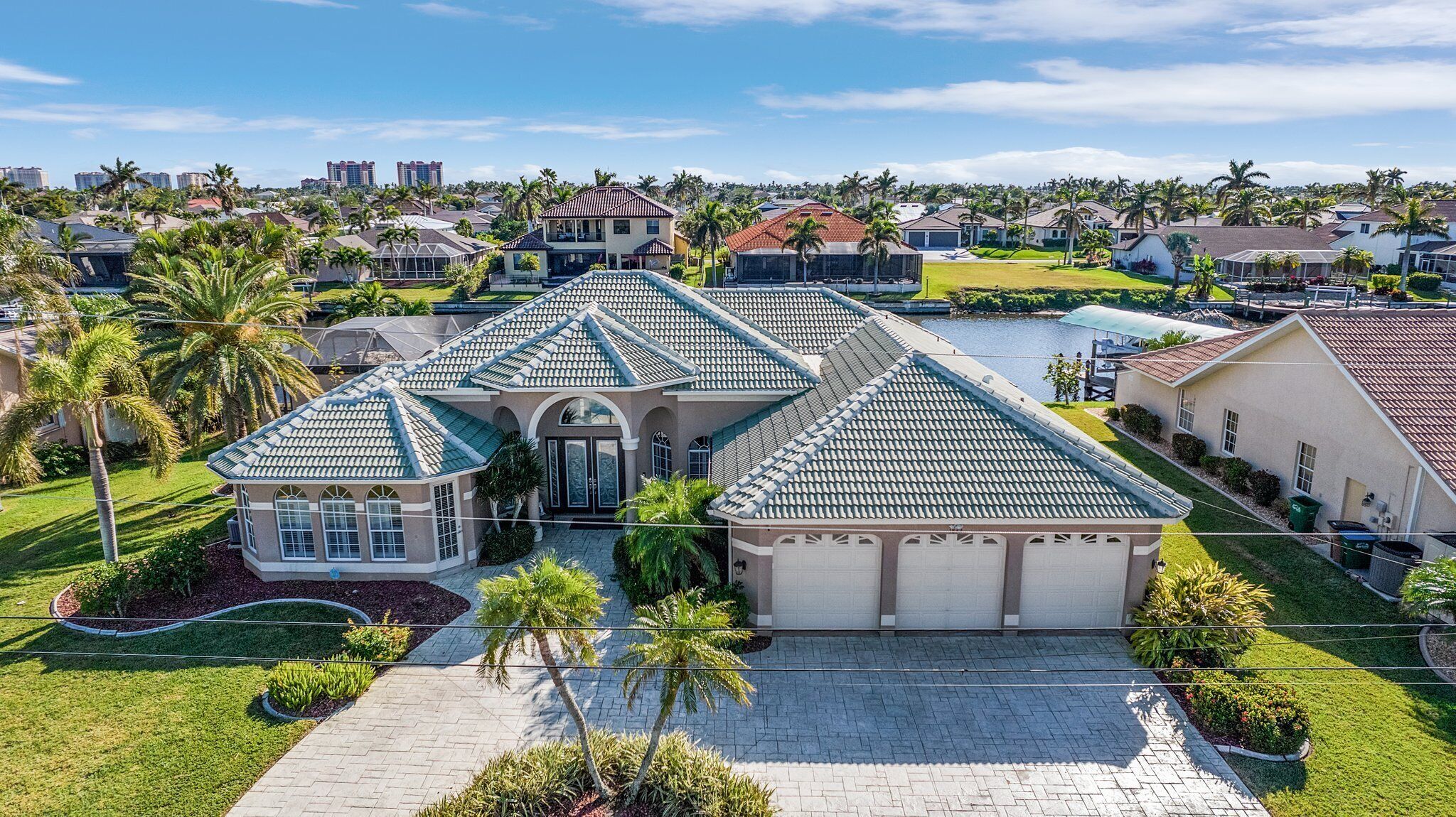 A large, single-story house with a tiled roof, a garage, and a well-maintained lawn.