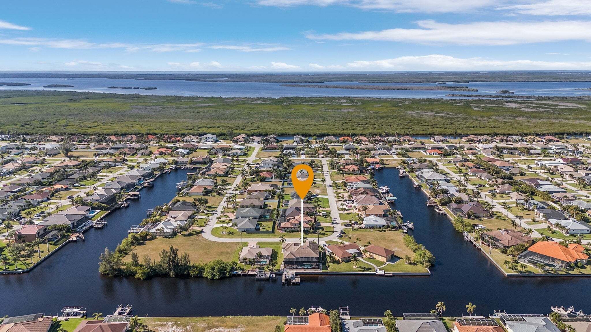 A residential area with a central waterway, houses, and docks.