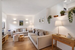 A modern living room with a sofa, coffee table, and lamp. - Pear Tree Holiday Home with Private Terrace, Wi-Fi, and Air Conditioning (Vale de Lobo)