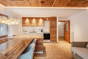 Une cuisine moderne avec des meubles en bois, un îlot central et des luminaires suspendus.