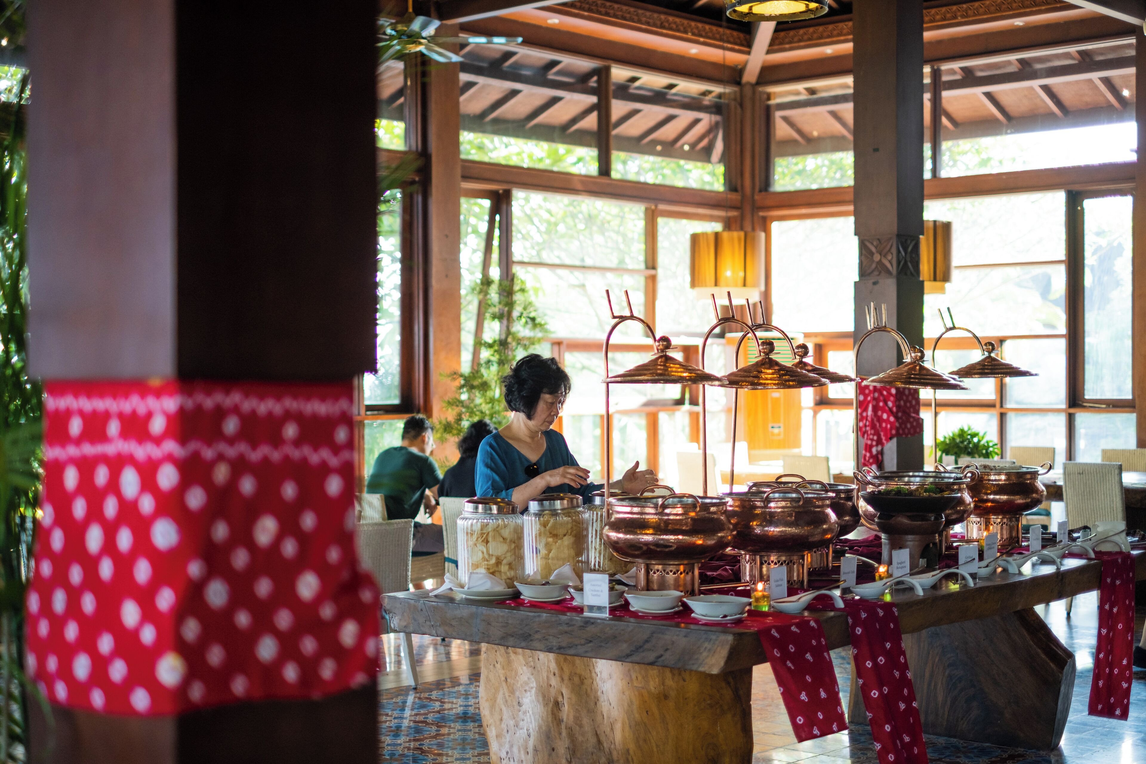 Disposição de buffet com diversos recipientes de comida e utensílios.