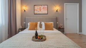 Ein Schlafzimmer mit einem Bett, zwei Nachttischen, einer Wandleuchte und einer Tür.