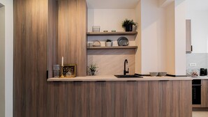 Eine moderne Küche mit einer Holztischinsel, eingebauten Regalen und einem schwarzen Wasserhahn.