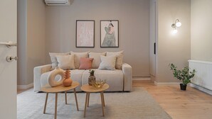 Ein Wohnzimmer mit einer Couch, zwei Beistelltischen und Dekorationselementen.
