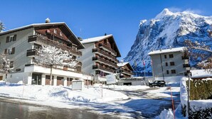 A snow-covered mountain town with modern buildings, a clear sky, and a prominent mountain peak in the background. - Cosy apartment for 3 people with WIFI, TV, balcony, pets allowed and panoramic view (Grindelwald)