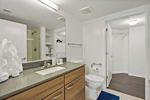 A modern bathroom with a sink, toilet, and shower area.
