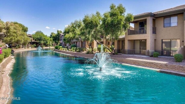 A swimming pool with a fountain, surrounded by trees and a building with balconies. - The Bridges? How Fancy! Waterview, Garage, Pool. (Chandler)