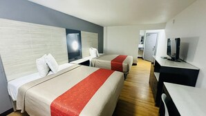 A hotel room with two beds, a desk, a television, and a mirror. - Evergreen Inn Portland Airport (Portland)