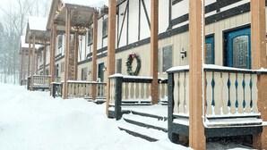 A row of wooden buildings with snow-covered steps and railings. - Slope Side Winter Villa I Alpen Villas at Powderhorn Mountain (Bessemer Township)