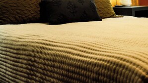 A wooden-paneled room with a bed, a wall-mounted artwork, and a nightstand with a lamp. - Slope Side Winter Villa I Alpen Villas at Powderhorn Mountain (Bessemer Township)
